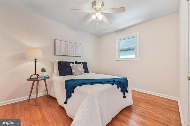 bedroom with baseboards, wood finished floors, and a ceiling fan