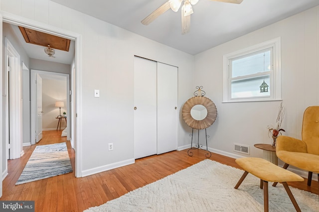 living area featuring baseboards, visible vents, attic access, and light wood-style floors