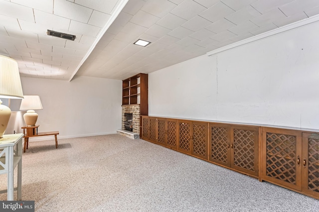 living area with a brick fireplace, carpet, and visible vents