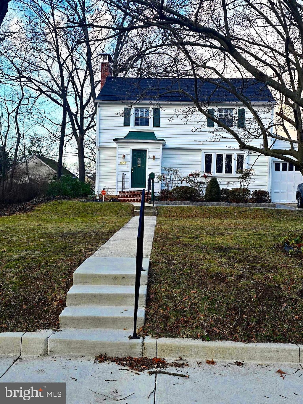 view of front of house with a chimney and a front lawn