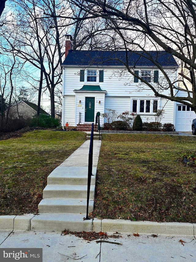 view of front of house with a chimney and a front lawn