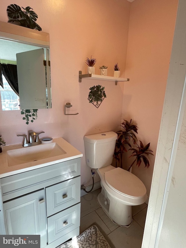 bathroom with tile patterned flooring, vanity, and toilet