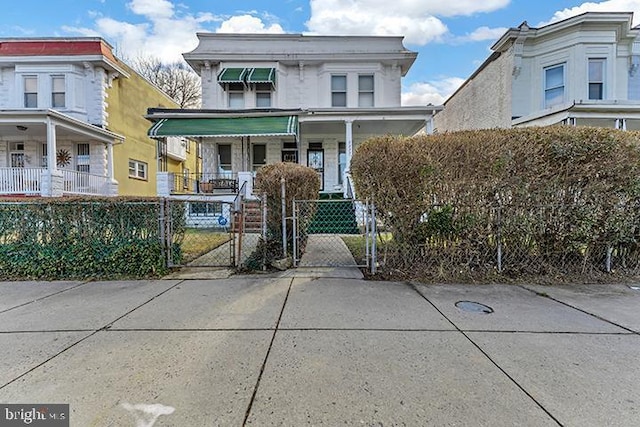 view of front of house featuring a porch, a fenced front yard, and a gate