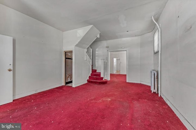 additional living space featuring stairs and radiator