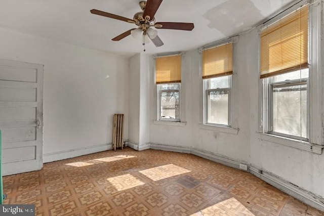 empty room featuring a ceiling fan and light floors