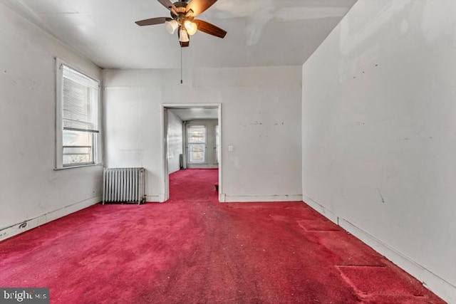 unfurnished room with radiator heating unit, carpet, and a ceiling fan