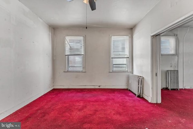 empty room featuring radiator heating unit and a ceiling fan