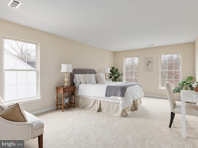 carpeted bedroom with visible vents, baseboards, and multiple windows