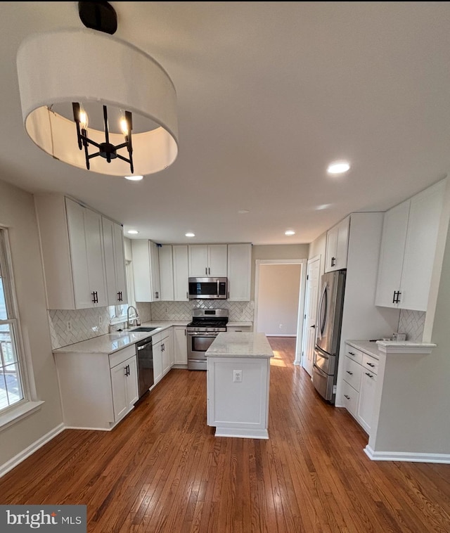 kitchen featuring stainless steel appliances, dark wood finished floors, white cabinets, and a sink