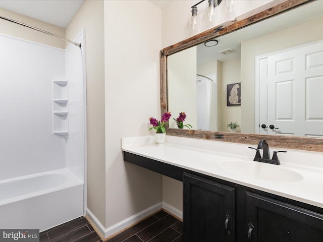 full bath featuring wood tiled floor, visible vents, vanity, and baseboards