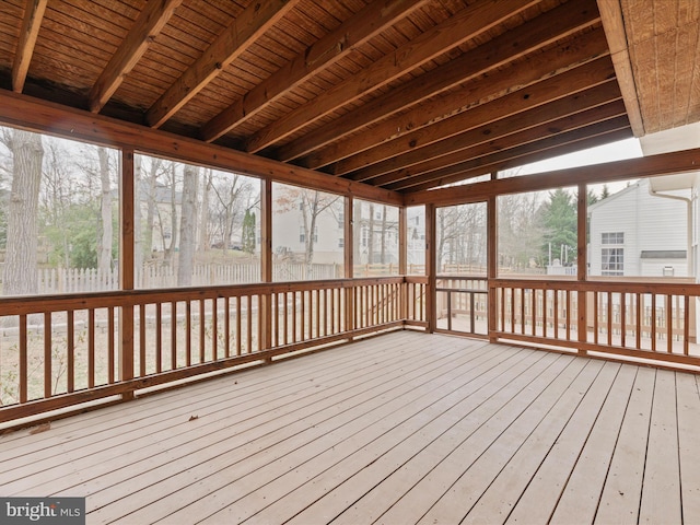 unfurnished sunroom with wood ceiling, a wealth of natural light, and beam ceiling