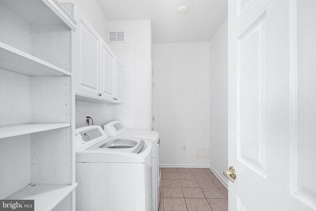 clothes washing area featuring light tile patterned floors, visible vents, baseboards, cabinet space, and washer and clothes dryer