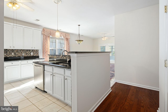 kitchen with dishwasher, pendant lighting, dark countertops, and white cabinets