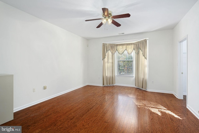 unfurnished room featuring ceiling fan, wood finished floors, visible vents, and baseboards