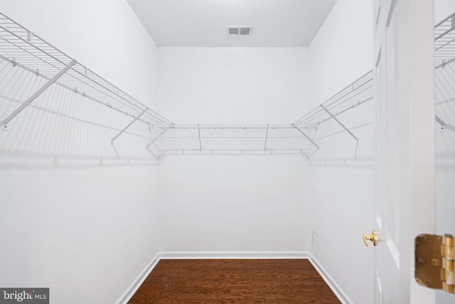 spacious closet with dark wood finished floors and visible vents