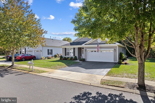 single story home with a front yard, concrete driveway, and an attached garage