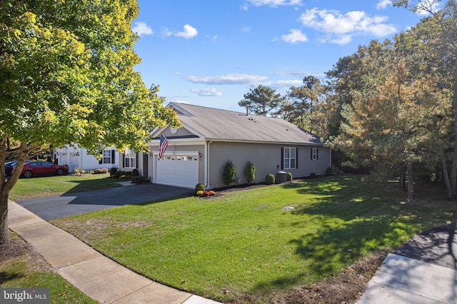 view of front facade with driveway, an attached garage, and a front lawn