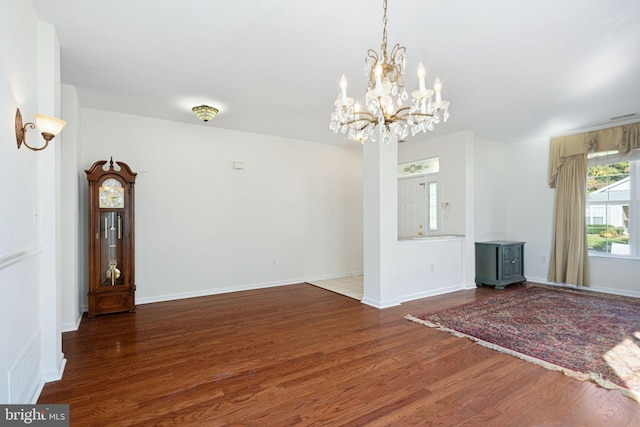 interior space with an inviting chandelier, visible vents, baseboards, and wood finished floors