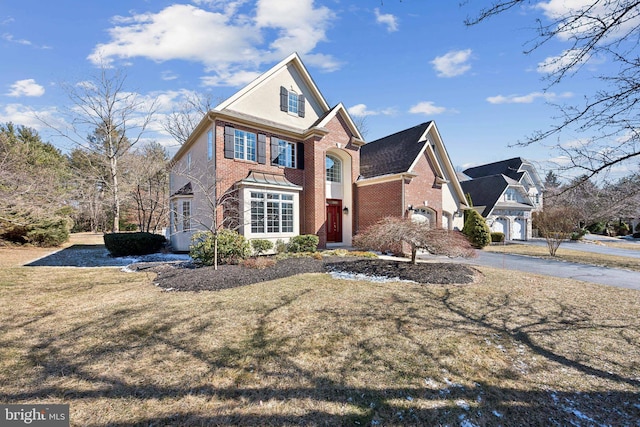 traditional-style house with a front lawn and brick siding