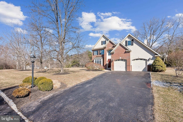 view of front of house with an attached garage, a chimney, aphalt driveway, and brick siding