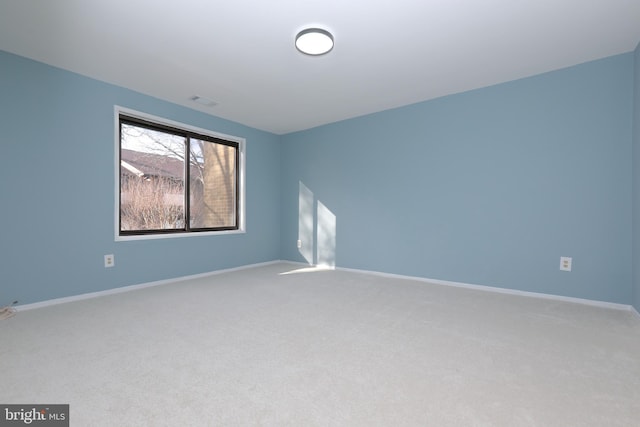 unfurnished room featuring carpet floors and baseboards