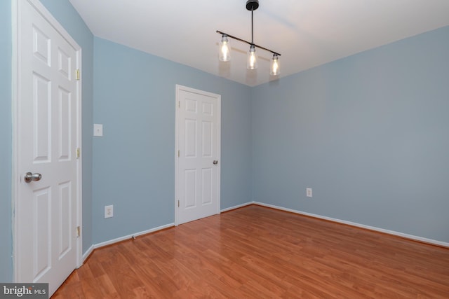 unfurnished room with wood finished floors and baseboards