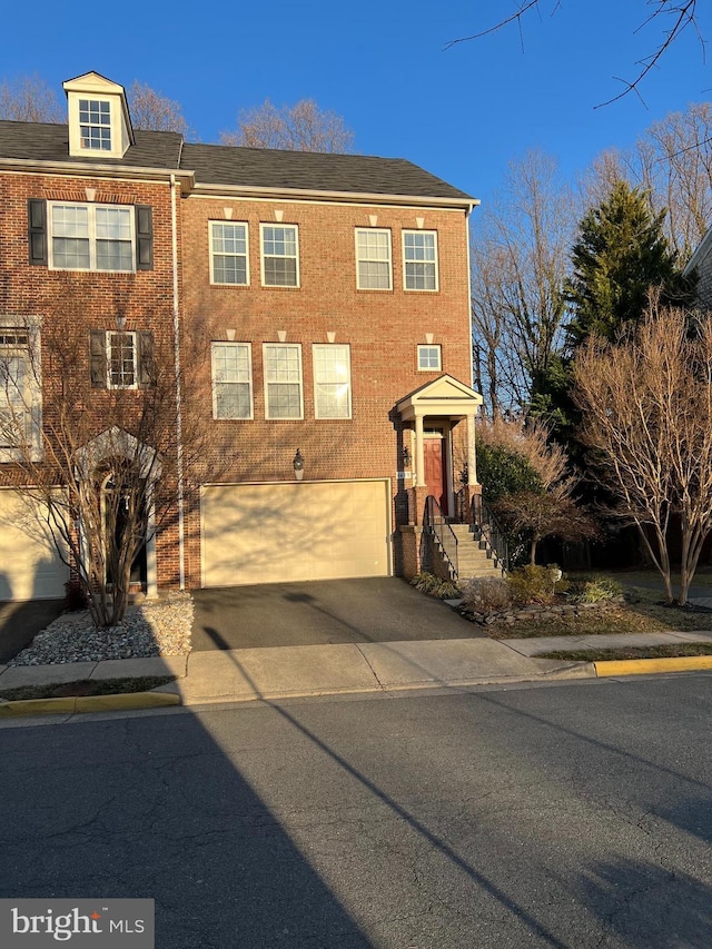 townhome / multi-family property featuring concrete driveway, brick siding, and an attached garage