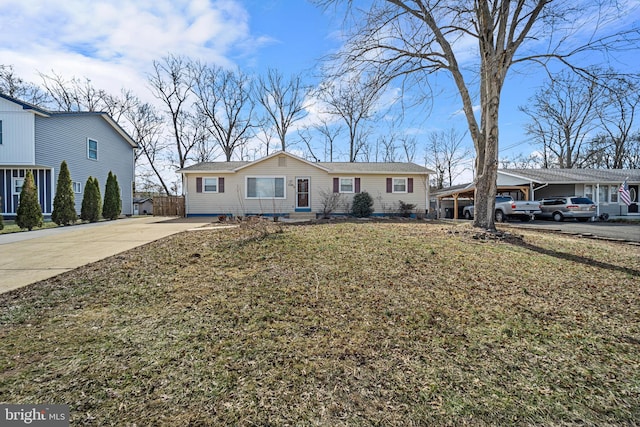 view of front of property featuring an attached carport, concrete driveway, and a front yard