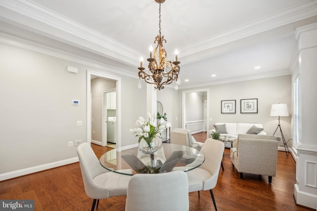 dining area with washer / dryer, a raised ceiling, baseboards, and wood finished floors