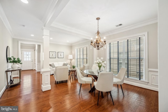 dining space featuring visible vents, dark wood-style floors, a wainscoted wall, ornamental molding, and ornate columns