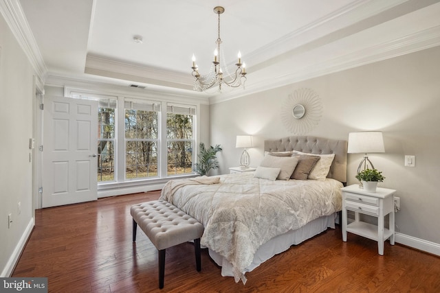 bedroom with crown molding, wood finished floors, a raised ceiling, and baseboards