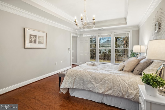 bedroom with a notable chandelier, crown molding, a raised ceiling, wood finished floors, and baseboards