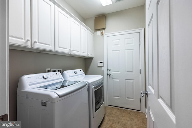 laundry room with washing machine and dryer, cabinet space, and visible vents