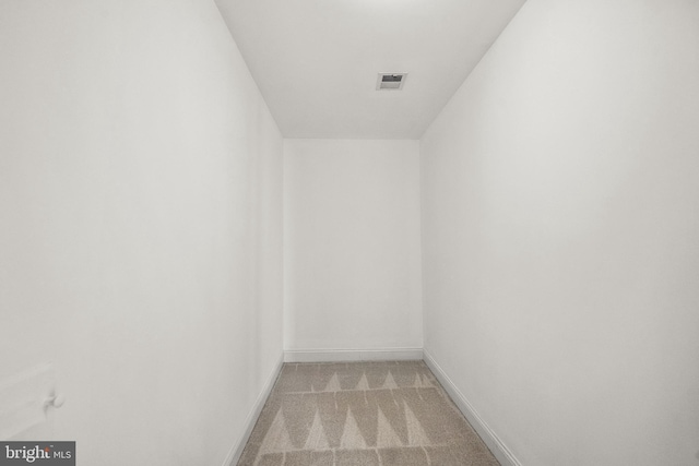 interior space featuring baseboards, visible vents, and light colored carpet