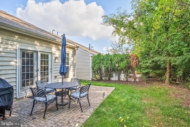 view of yard featuring french doors, a patio area, and outdoor dining space