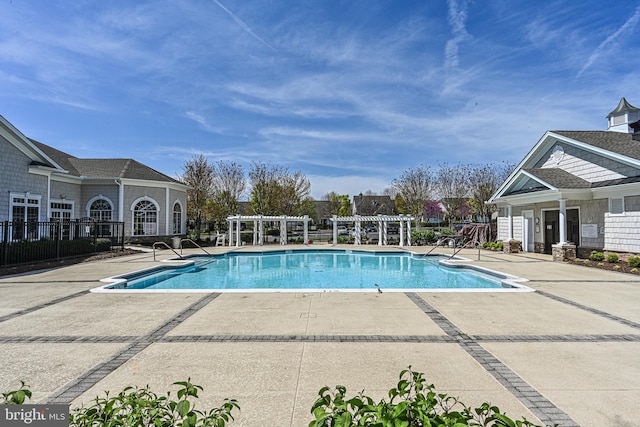 pool with a patio, fence, and a pergola