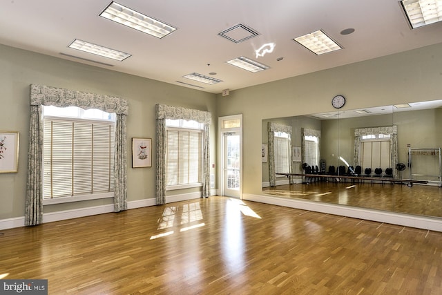 workout area with baseboards and wood finished floors