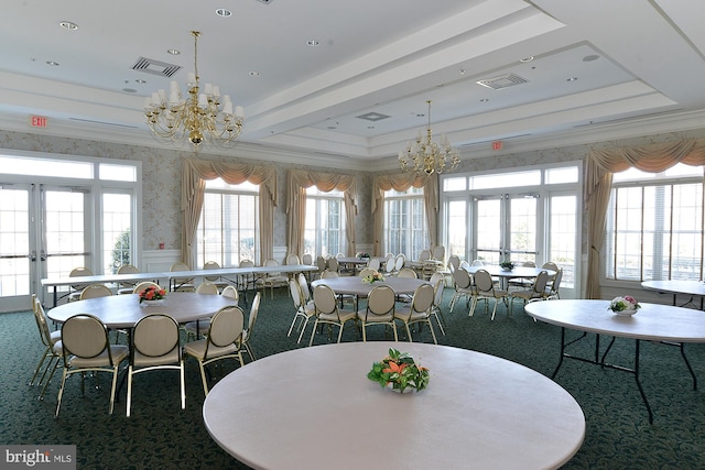 dining area featuring a notable chandelier, visible vents, a tray ceiling, and french doors