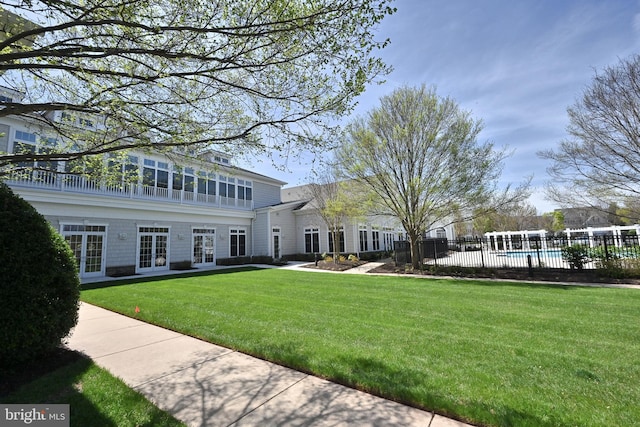 view of front of home featuring a fenced in pool, a front yard, french doors, and fence