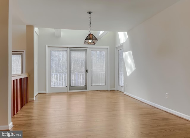 interior space featuring a wealth of natural light, baseboards, and wood finished floors