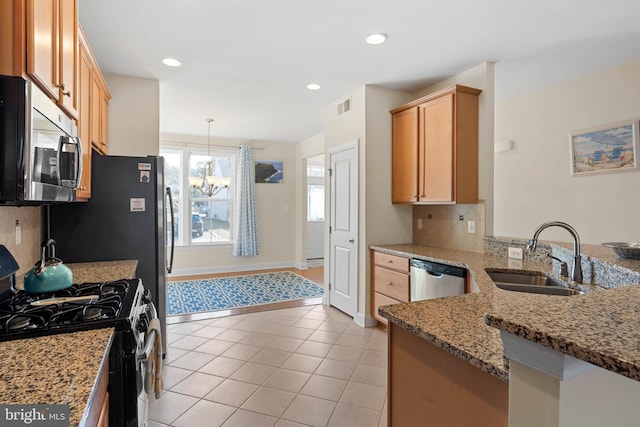 kitchen featuring visible vents, a sink, stainless steel appliances, a peninsula, and decorative backsplash