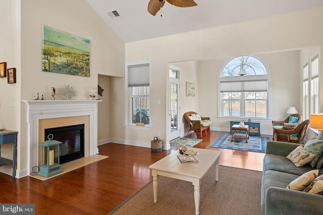 living area featuring visible vents, wood finished floors, ceiling fan, and a fireplace with flush hearth