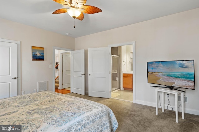 bedroom with visible vents, a ceiling fan, ensuite bath, baseboards, and light colored carpet