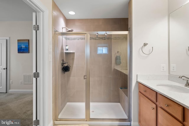 full bath featuring vanity, a shower stall, and visible vents