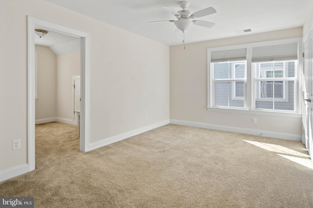 carpeted spare room with visible vents, baseboards, and ceiling fan