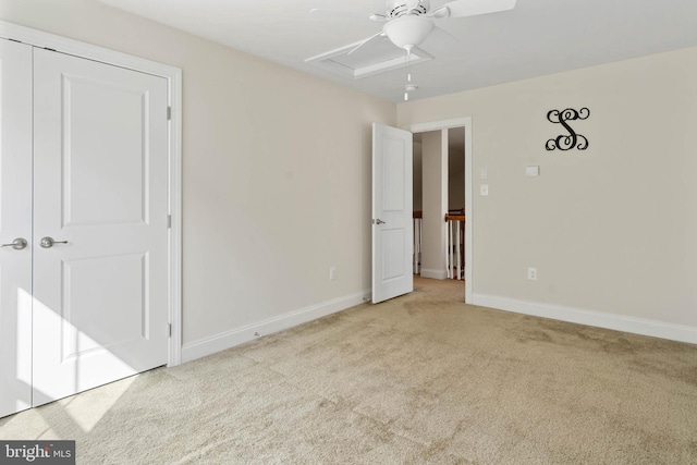 unfurnished bedroom with ceiling fan, baseboards, carpet, attic access, and a closet