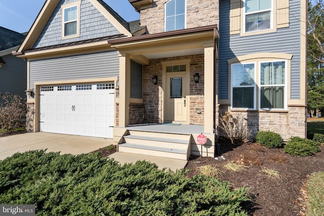 property entrance with metal roof, a garage, stone siding, driveway, and a standing seam roof