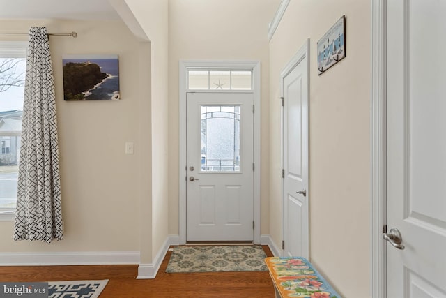 foyer with baseboards and wood finished floors