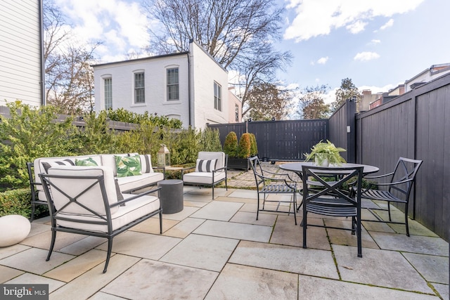 view of patio / terrace with a fenced backyard, an outdoor living space, and outdoor dining space