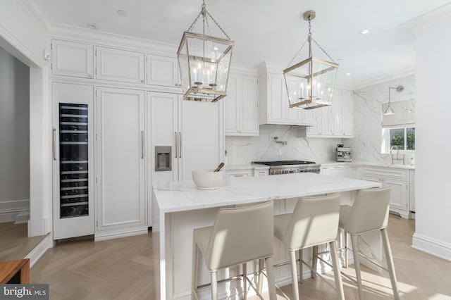 kitchen with light stone counters, tasteful backsplash, white cabinetry, a kitchen island, and range